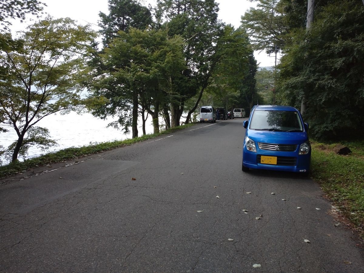 湖沿いに止まる軽自動車